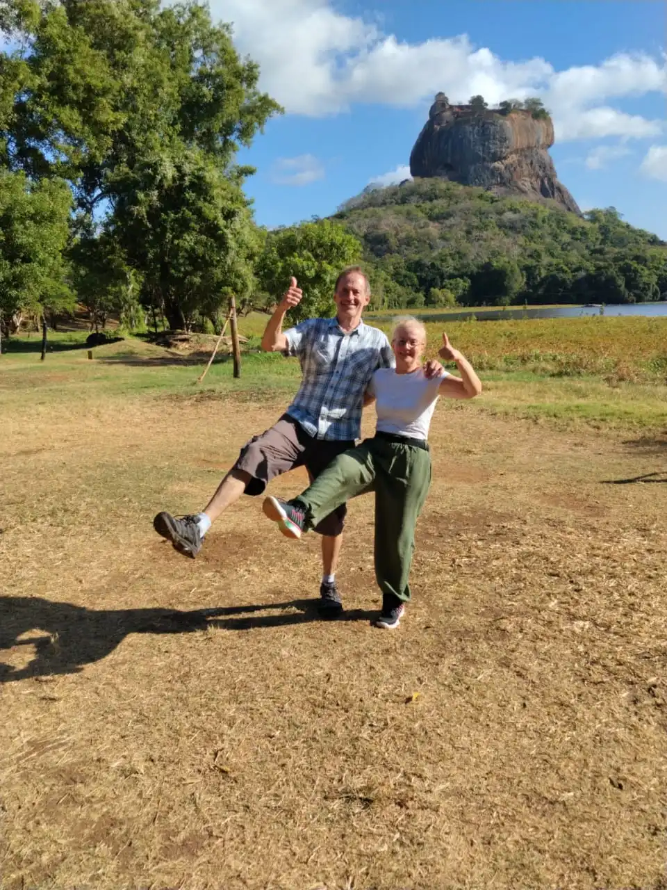 Adventurous travelers celebrating their visit in front of Sigiriya Lion Rock fortress